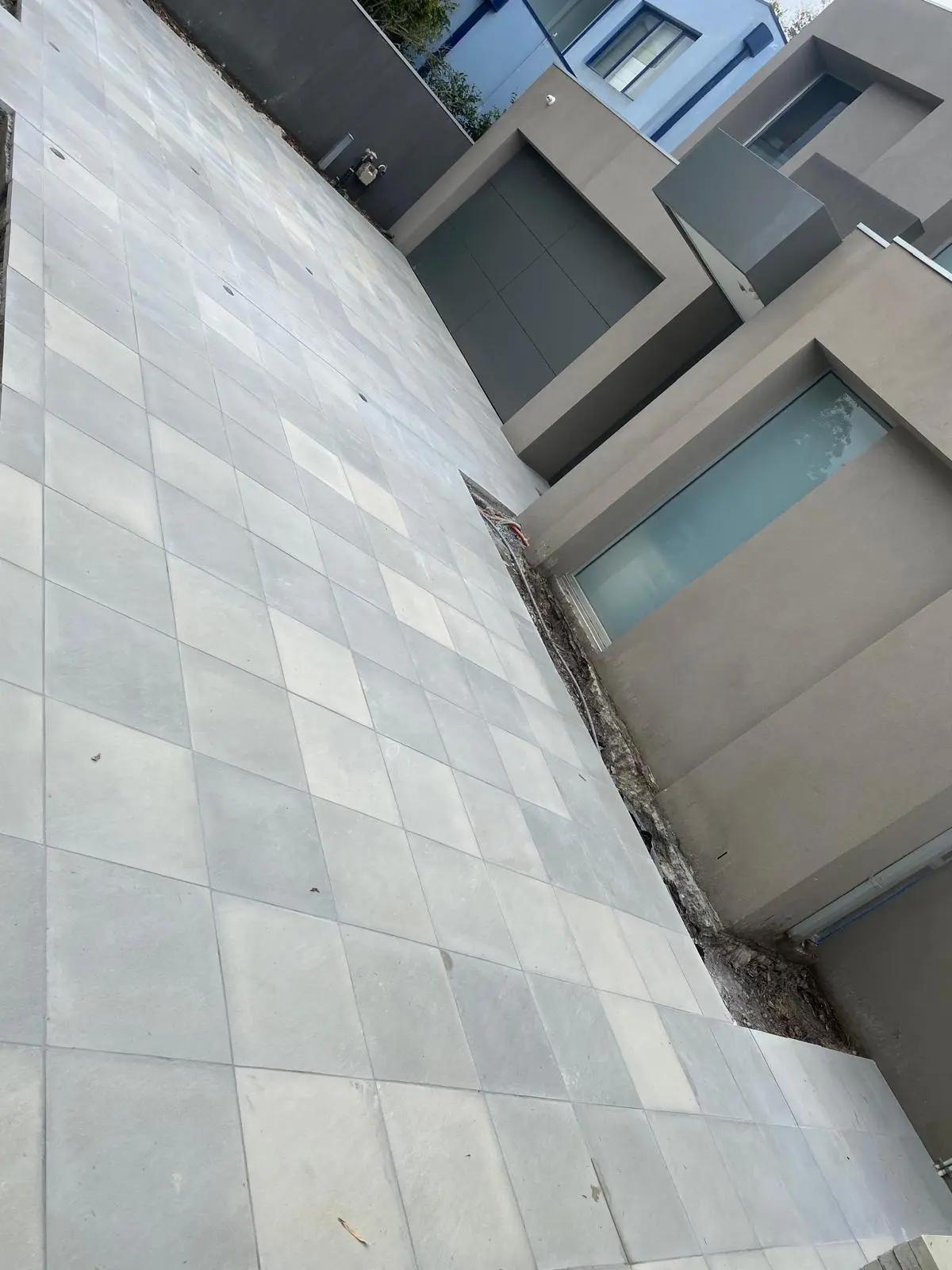 Outdoor deck area with large-format textured stone tiles